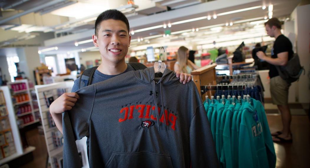 student holding up shirt in Stockton bookstore